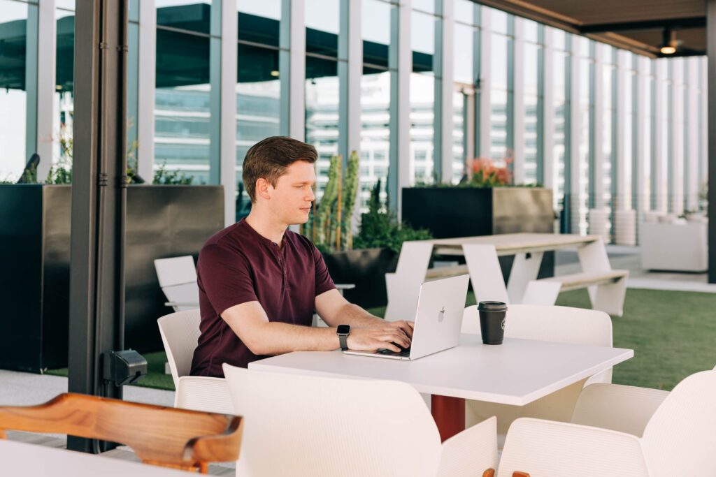 AI Search Optimization: Image of people working on a laptop at a table.