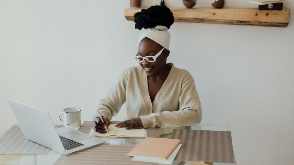 Woman working at desk on computer to represent how to blog on wordpress as a showit user