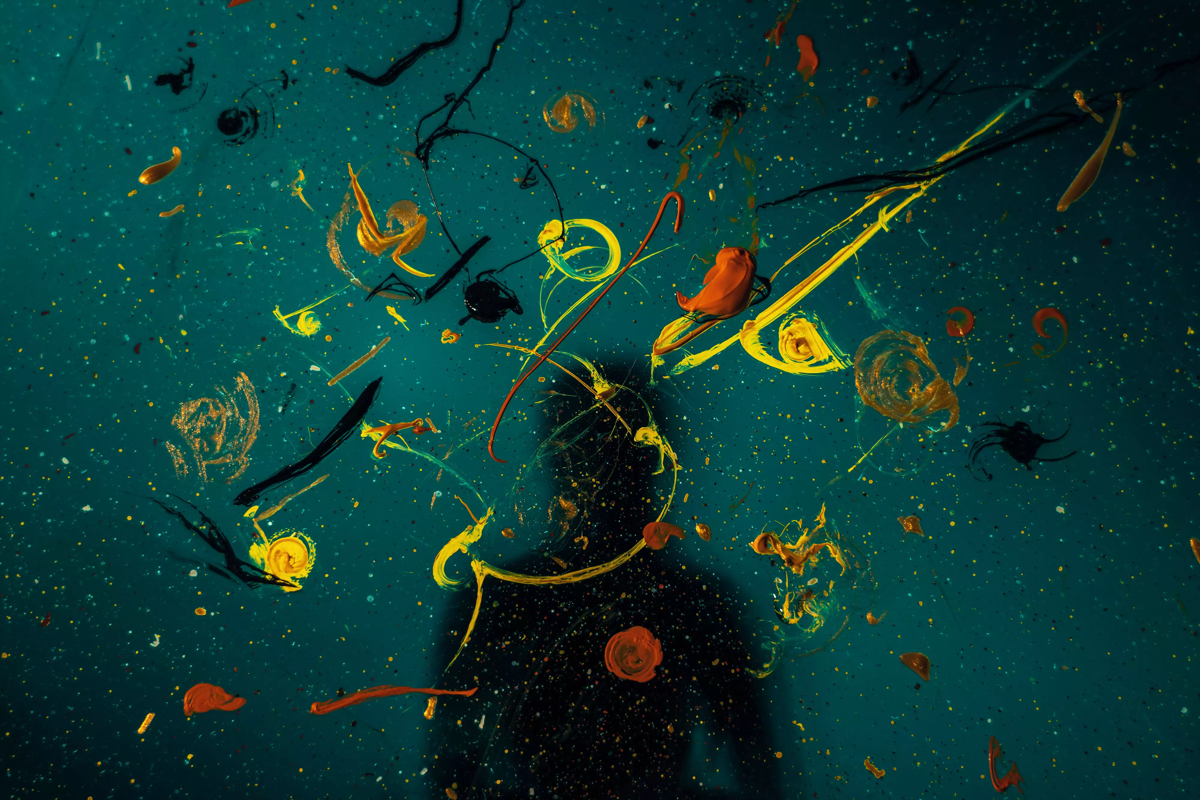 cultivate-more-creativity-featured - Showit A canvas with paint splattered and a silhouette of a person to illustrate how to cultivate more creativity